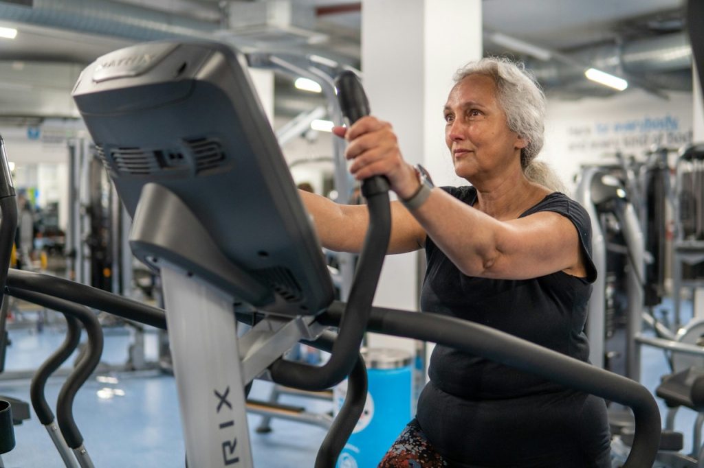 woman at gym using low impact cardio machine