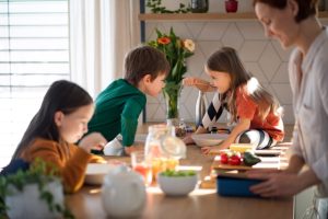 busy parent making breakfast for three children